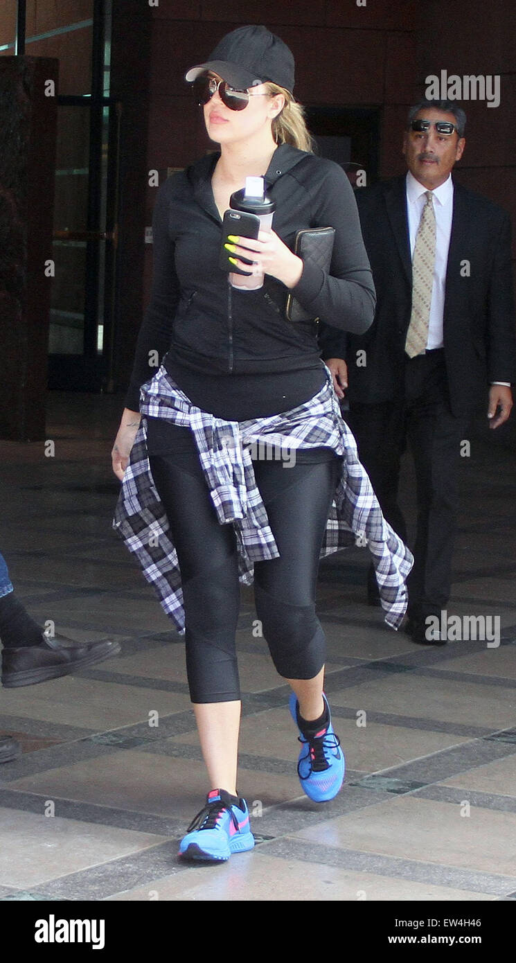 Khloe Kardashian va a un salón de belleza en Beverly Hills, vistiendo ropa  deportiva negra coincidente con una gorra de béisbol y una camisa de  cuadros para envolverse alrededor de su cintura