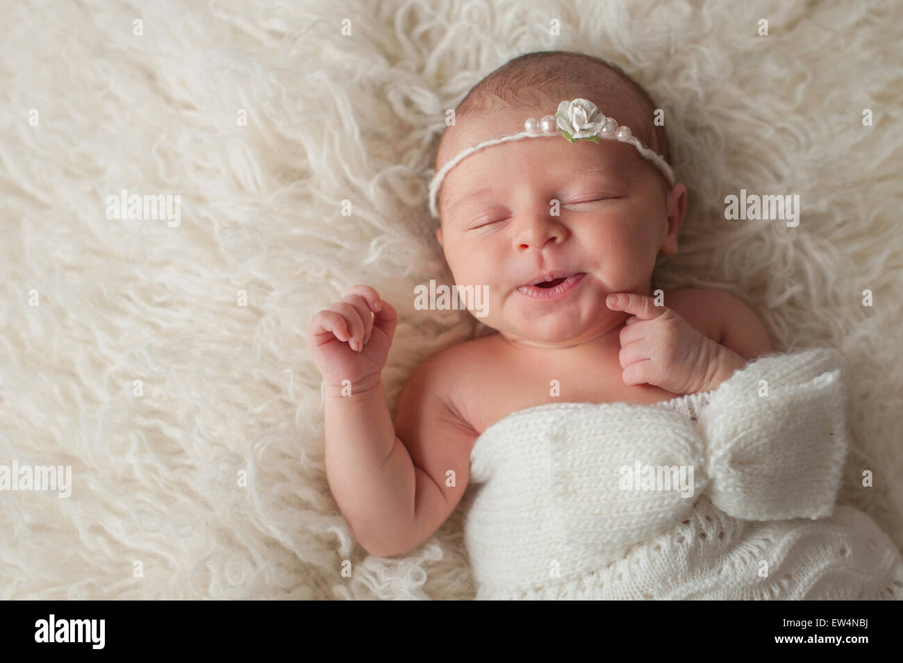 Los siete días de la antigua niña recién nacida con una bonita expresión.  Ella está durmiendo en un color crema flokati Fotografía de stock - Alamy