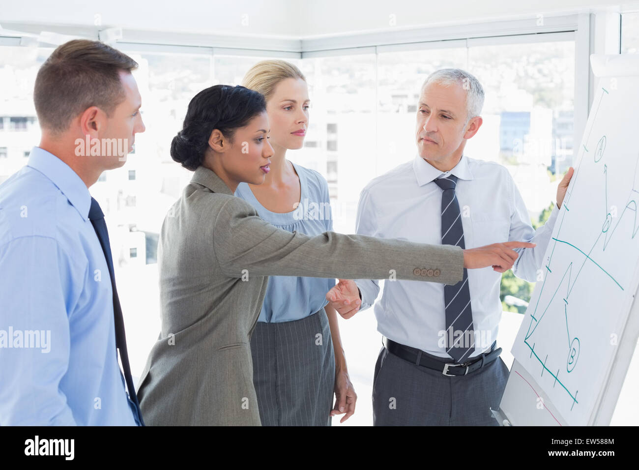 Equipo empresarial hablando de el gráfico en la pizarra Foto de stock