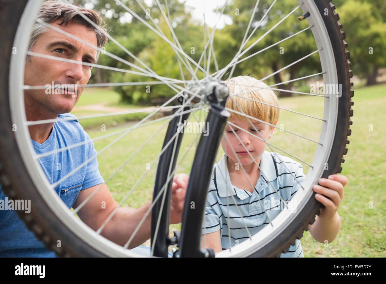 El padre y su hijo una bicicleta de fijación Foto de stock