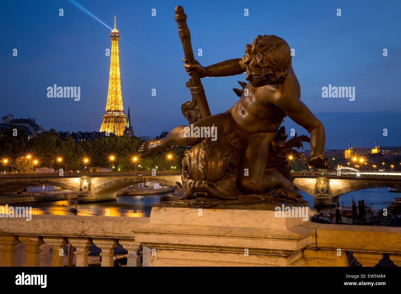 Twilight en estatua en Puente Alexandre III con el río Sena y de la Torre Eiffel, más allá, París, Francia Foto de stock