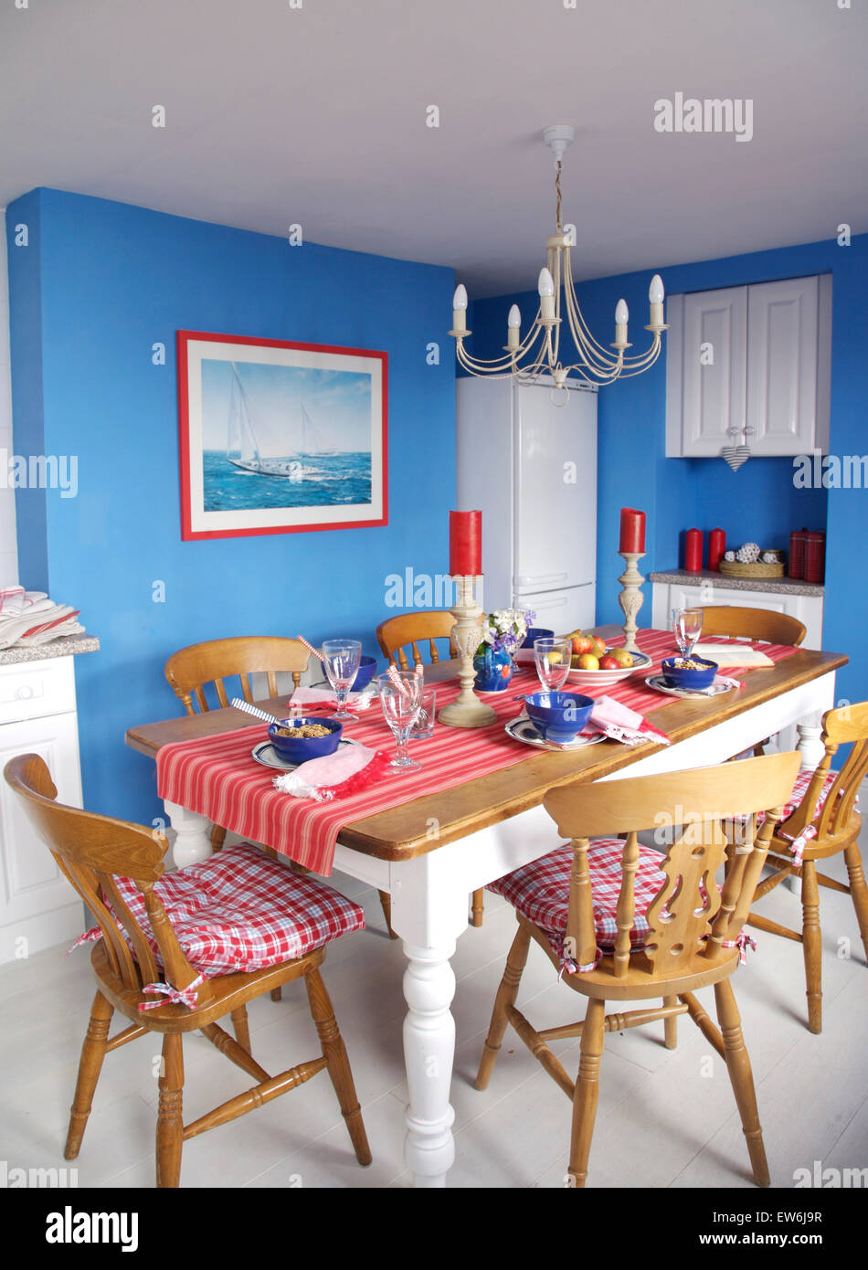 Comprobar rojo cojines sillas de madera pintadas en azul en la mesa de  comedor cocina costera Fotografía de stock - Alamy