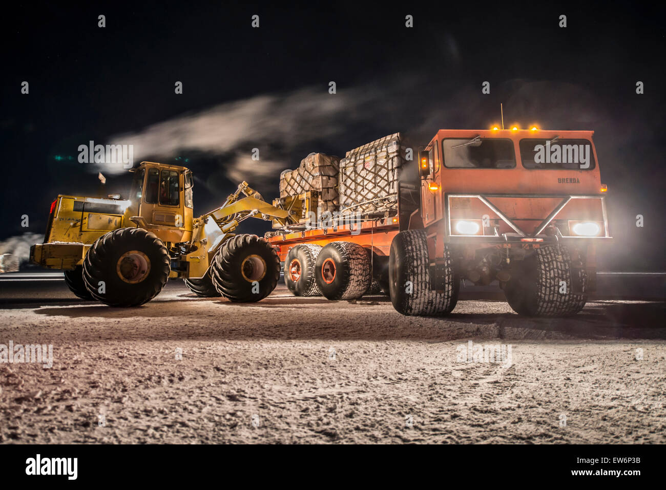 Colocar la carga en un camión con ruedas grandes en la Estación McMurdo, en la Antártida. Foto de stock