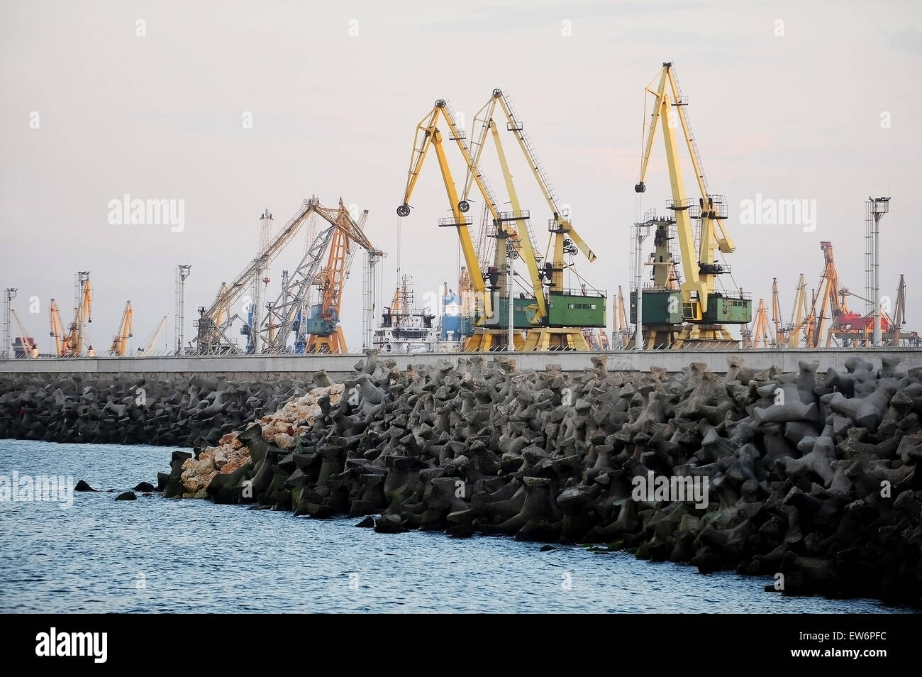 Puerto industrial con grúas de carga al atardecer Foto de stock