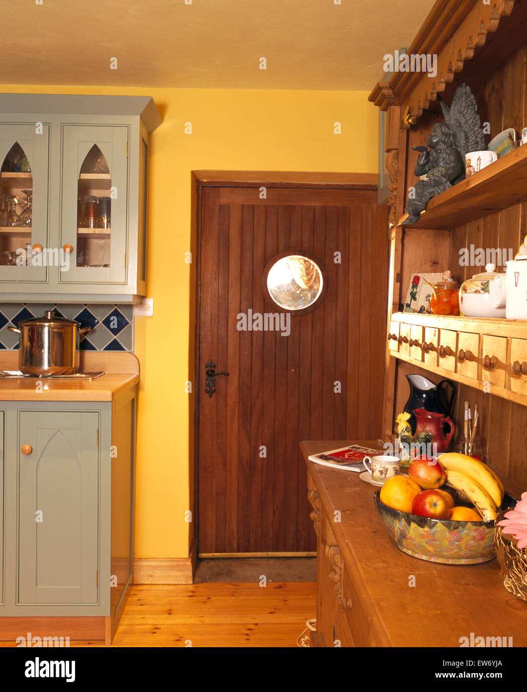 Puerta de madera oscura y aparador de madera en amarillo 90 Cocina con  armarios empotrados de color gris pálido Fotografía de stock - Alamy