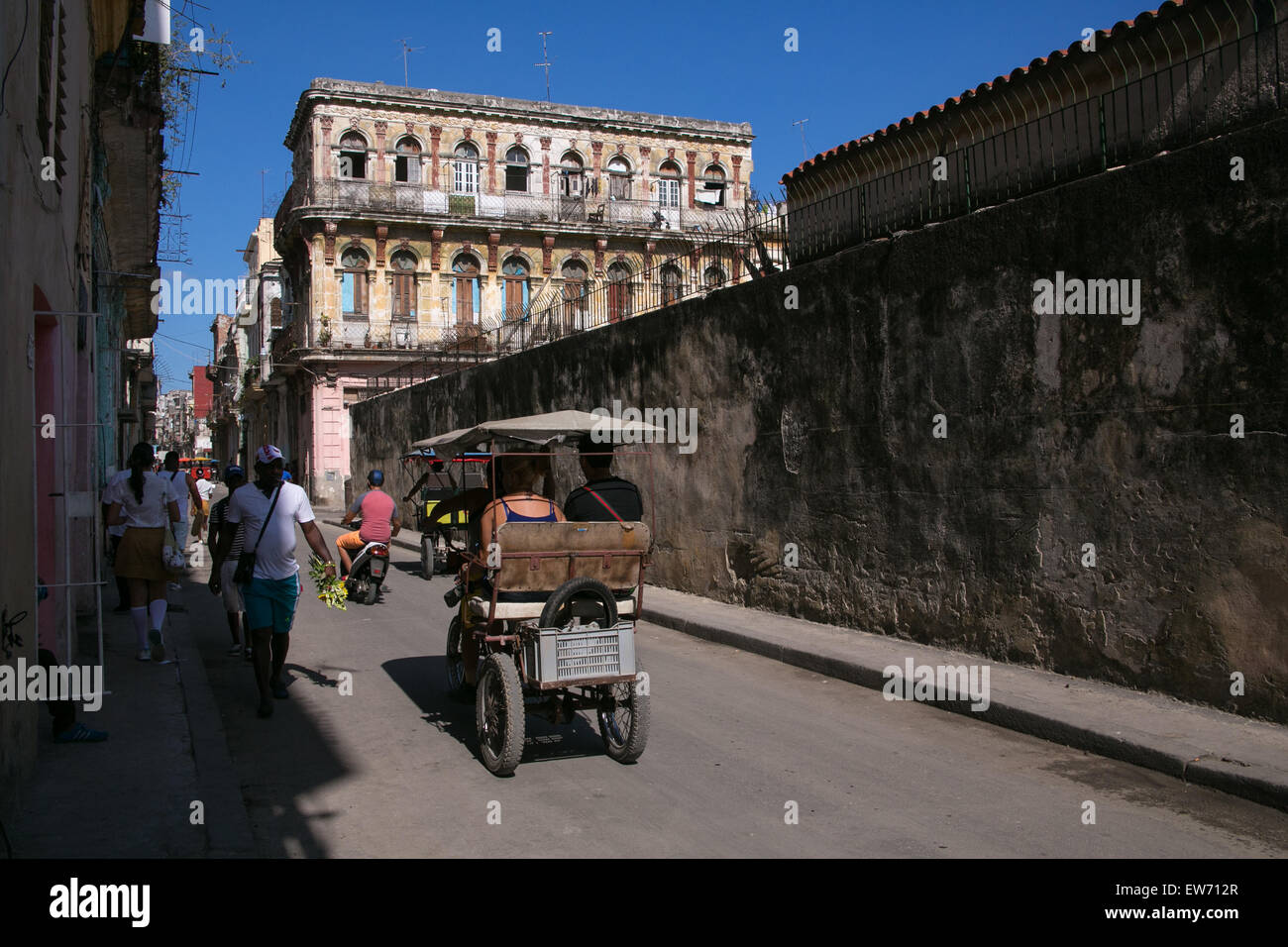 Un triciclo y peatones en La Habana Vieja, Cuba. Foto de stock