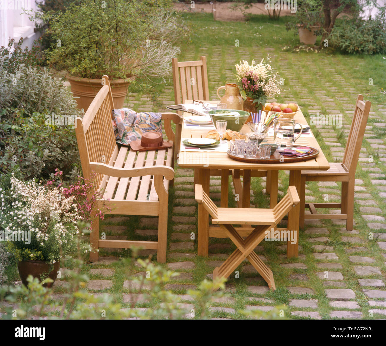 Banco de madera y sillas en la mesa para comer en el patio jardín campestre  en Francés Fotografía de stock - Alamy