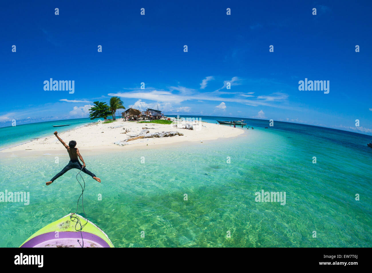 Adolescente saltando desde la parte delantera de un barco en el mar, Semporna, Sabah, Malasia Foto de stock