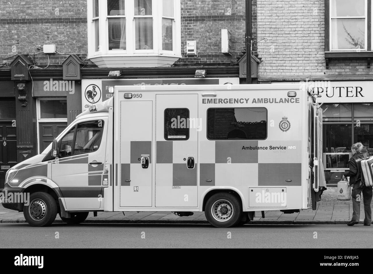 CAMBRIDGE, Inglaterra - 7 de mayo de 2015: Inglaterra NHS Ambulancia paramédico para responder a una emergencia en Mill Road, Cambridge monocromo i Foto de stock