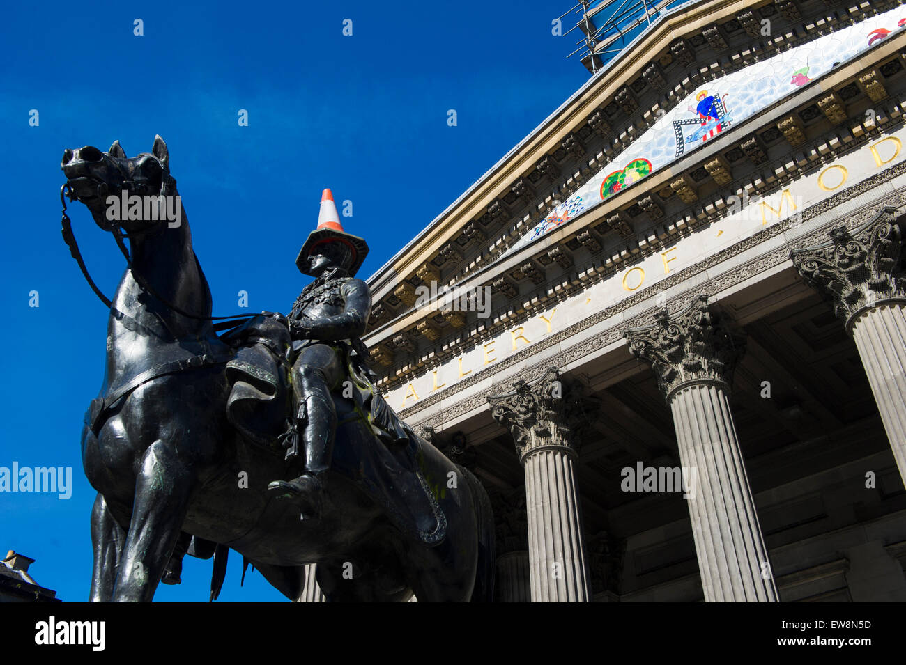 Estatua del Duque de Wellington, con conos de tráfico fuera del Museo de Arte Moderno de Glasgow, Escocia, con un cono de tráfico sobre su cabeza. Foto de stock
