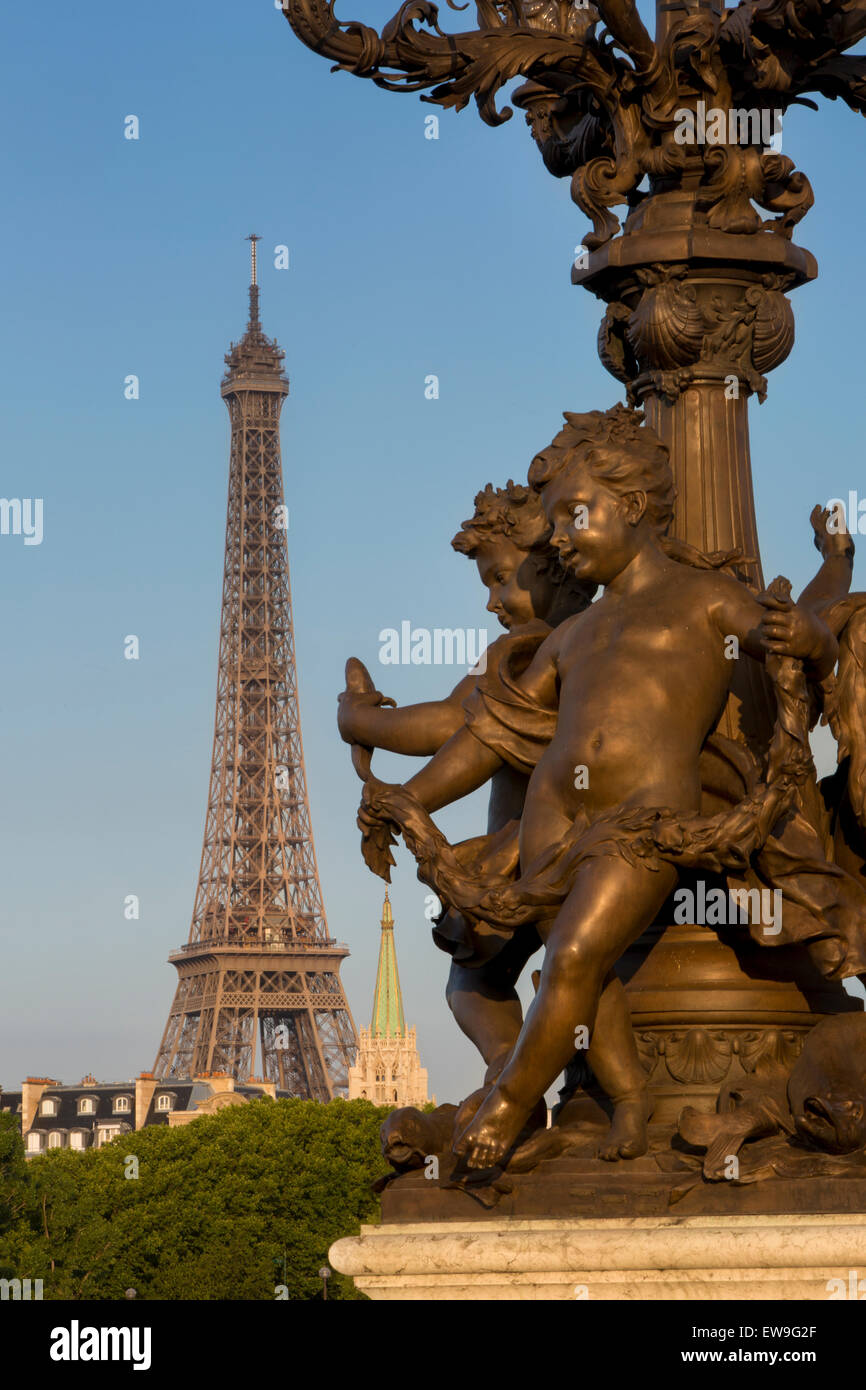 Querubín estatua en farola junto Pont Alexndre III con más allá de la Torre Eiffel, Paris, Francia Foto de stock