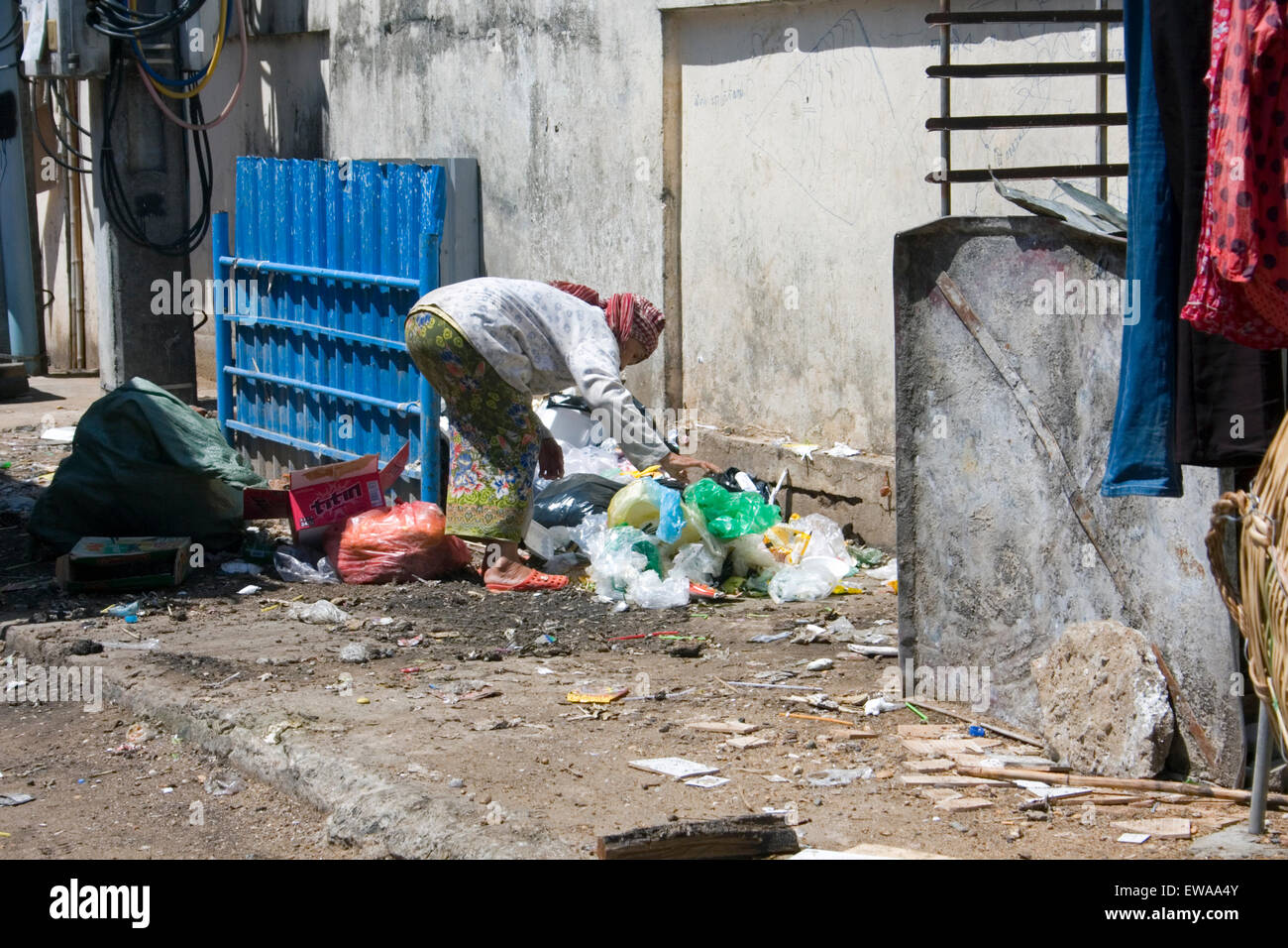 Una anciana es la compactación de material reciclable a través de plástico en una calle de la ciudad de Kampong Cham, Camboya. Foto de stock