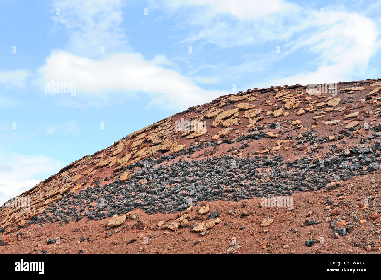 Lanzarote, Islas Canarias, España. Diferentes tipos de rocas volcánicas en la ladera de una colina roja, en el Parque Nacional de Timanfaya. Foto de stock