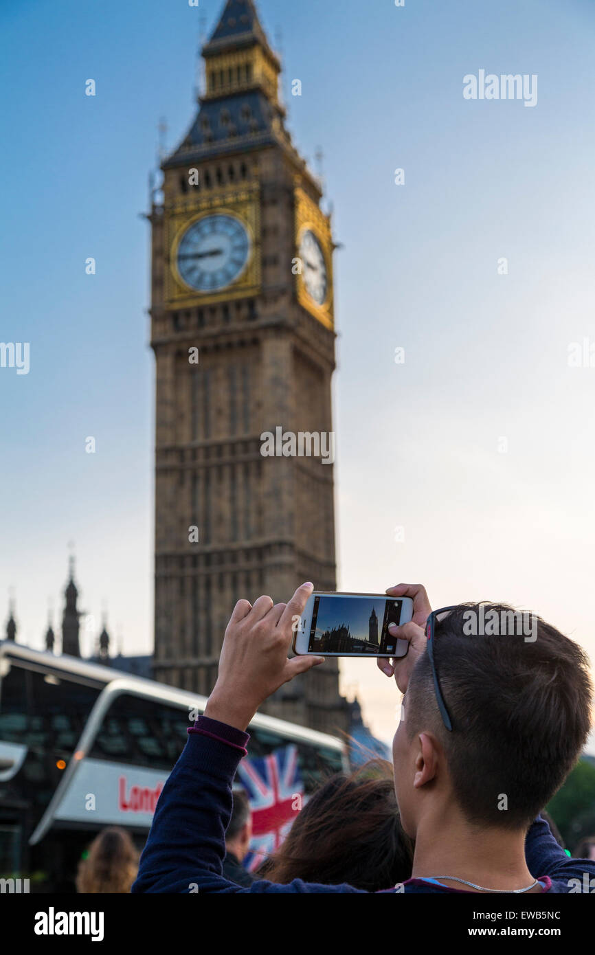 Imagen de retrato de un turista toma una foto del Big Ben en un teléfono inteligente de Westiminster puente en una clara tarde de verano, Londres, Inglaterra, Reino Unido. Foto de stock