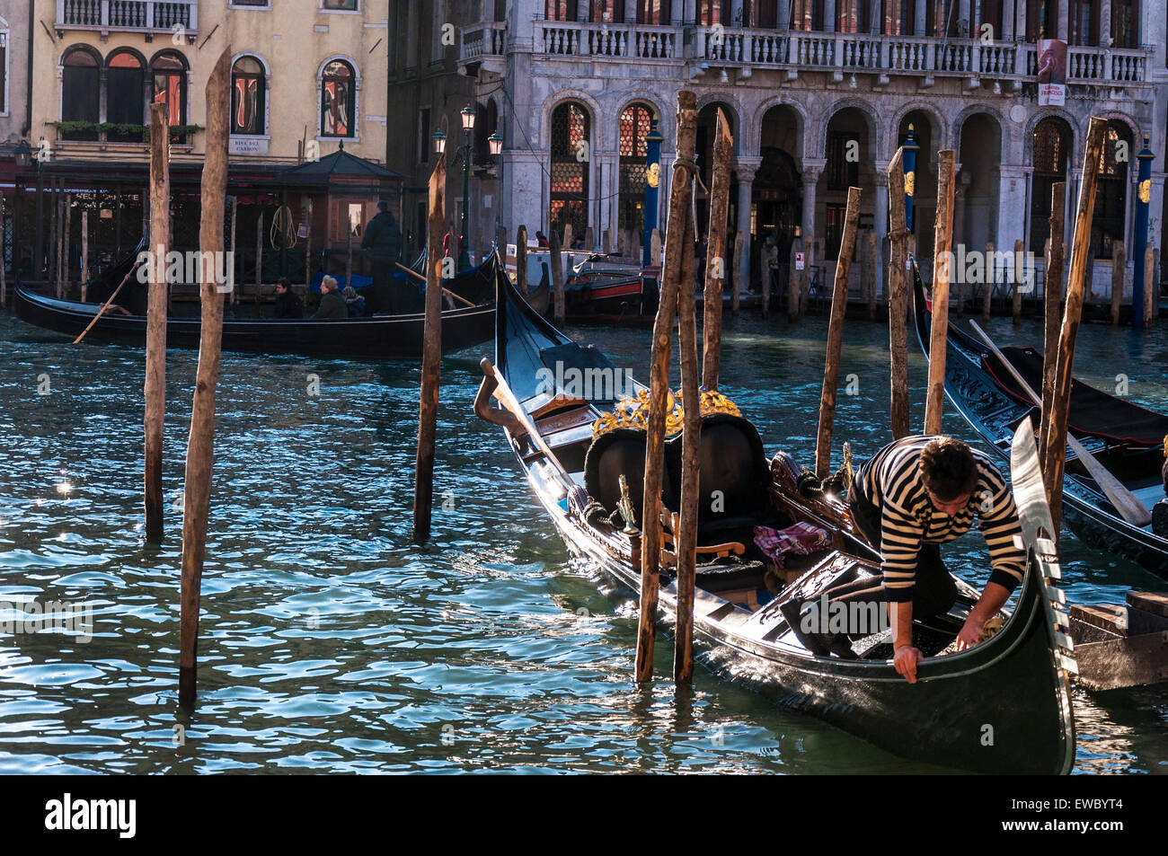 Gondolero limpia su góndola por el Gran Canal de Venecia Venecia Italia Foto de stock