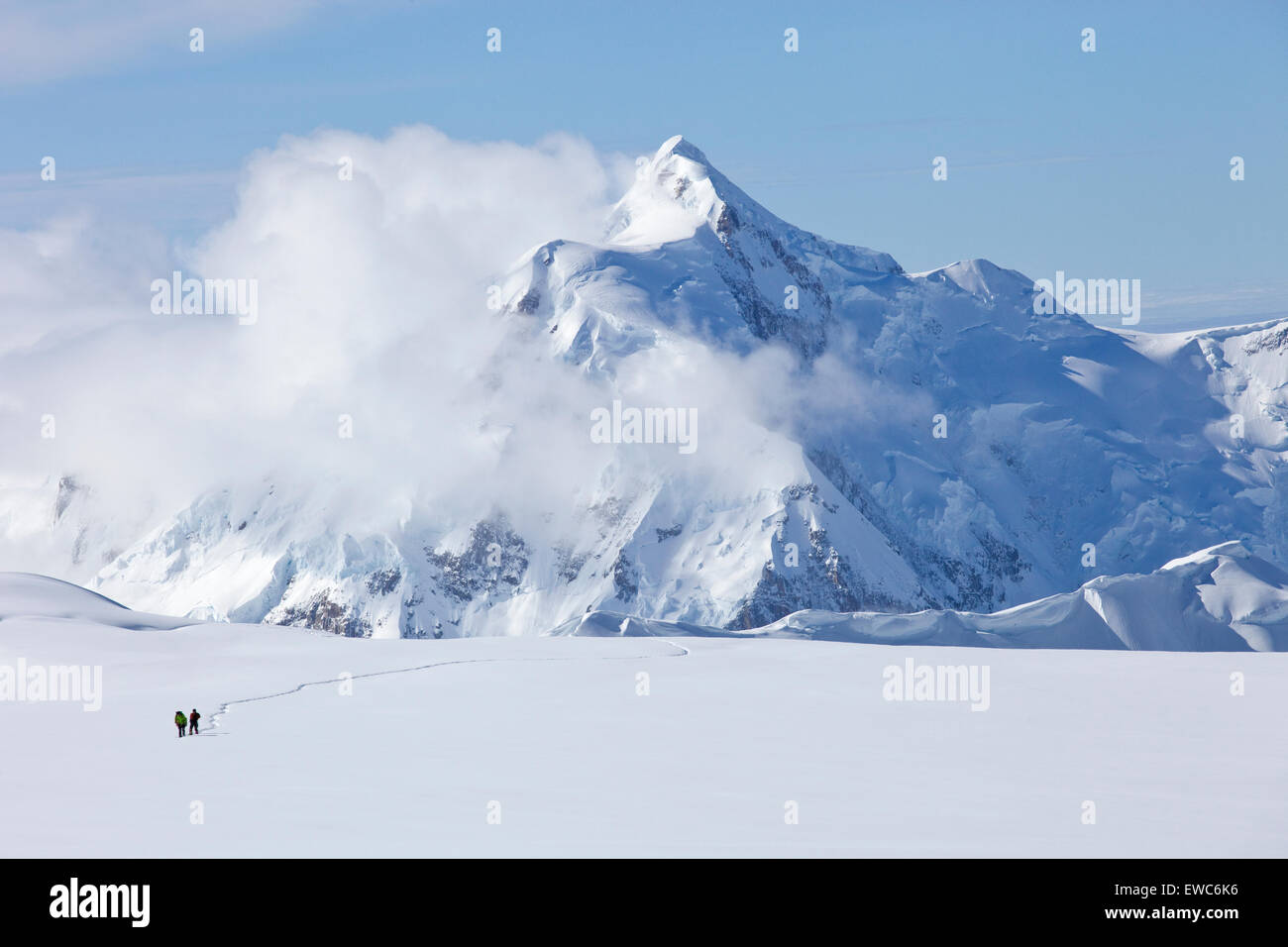 Dos montañeros están cruzando un glaciar en Mt. McKinley, Alaska. Monte Hunter es en el fondo. Foto de stock