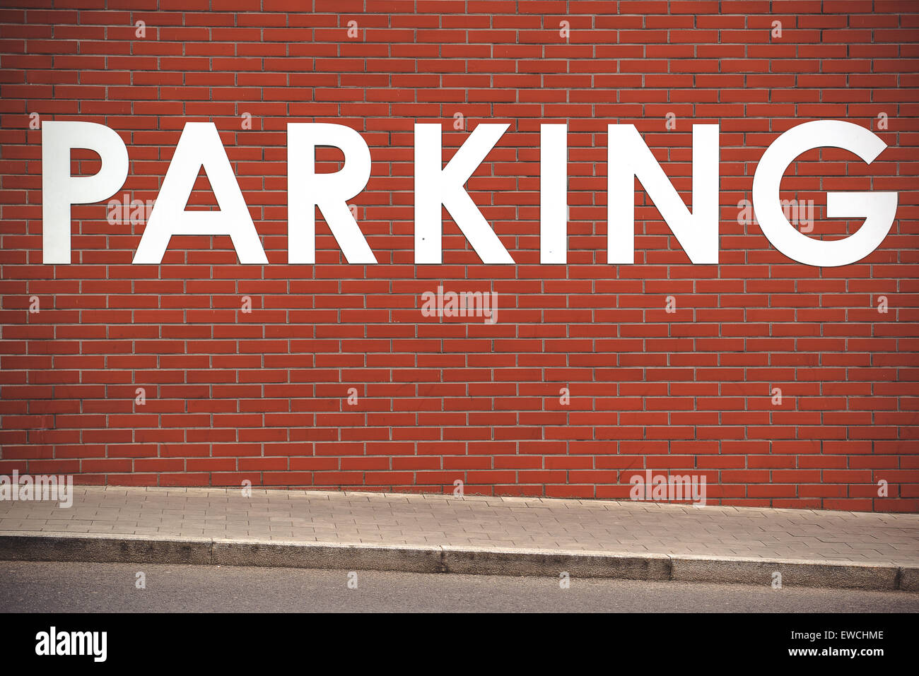 Título de estacionamiento sobre pared de ladrillo, signo de la calle, espacio de estacionamiento del vehículo. Foto de stock