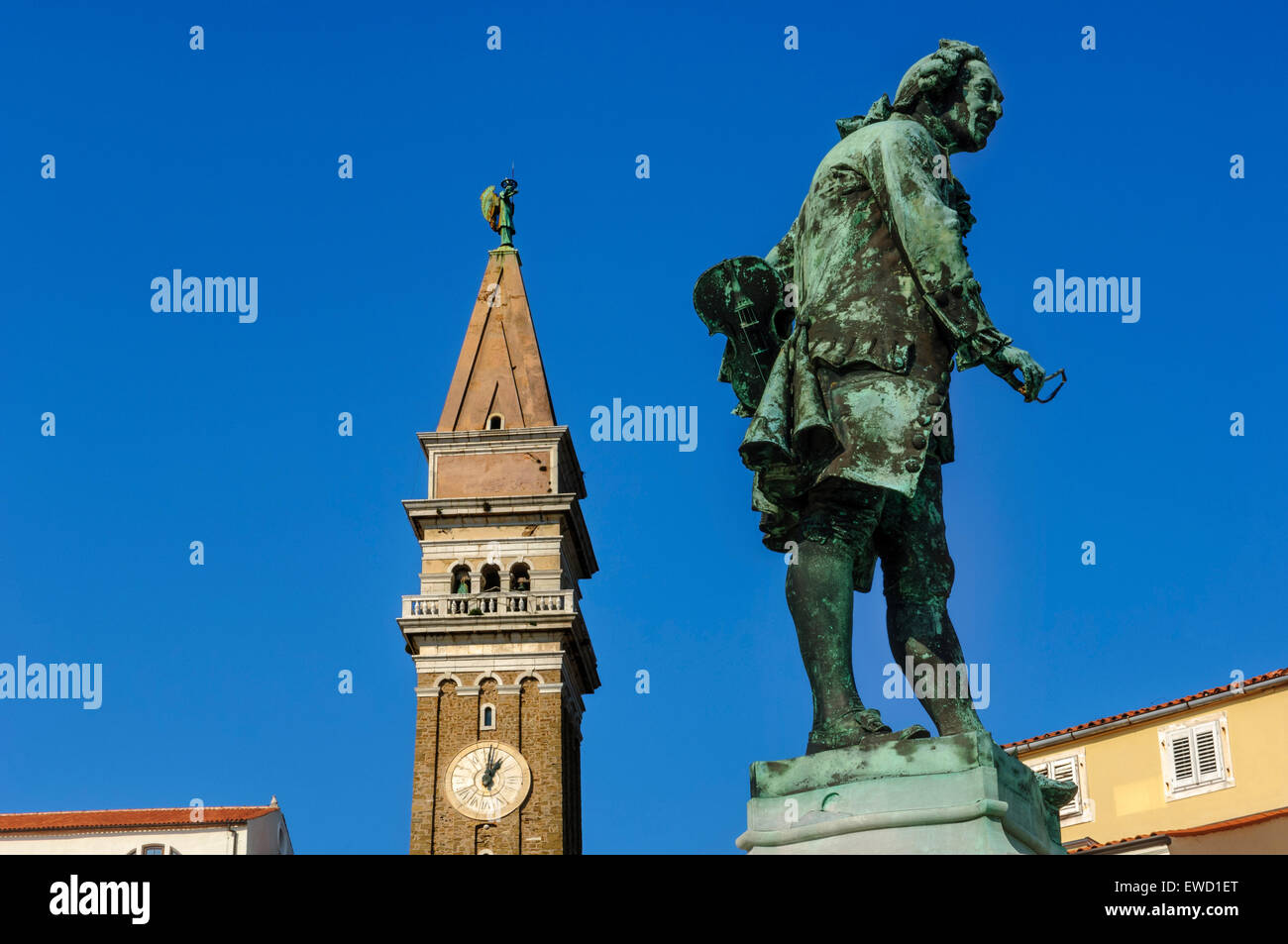 Estatua del violinista y compositor local Giuseppe Tartini y la torre del reloj de la Catedral de San Jorge. Piran. Eslovenia Foto de stock