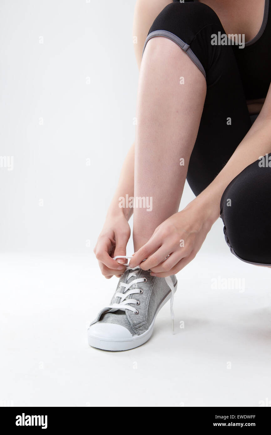 Cerca de la imagen de una mujer atar sus cordones de sus zapatos Fotografía  de stock - Alamy