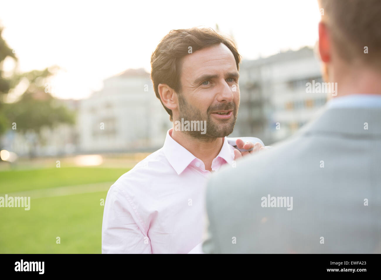 El empresario conversando con su colega en el parque en día soleado Foto de stock