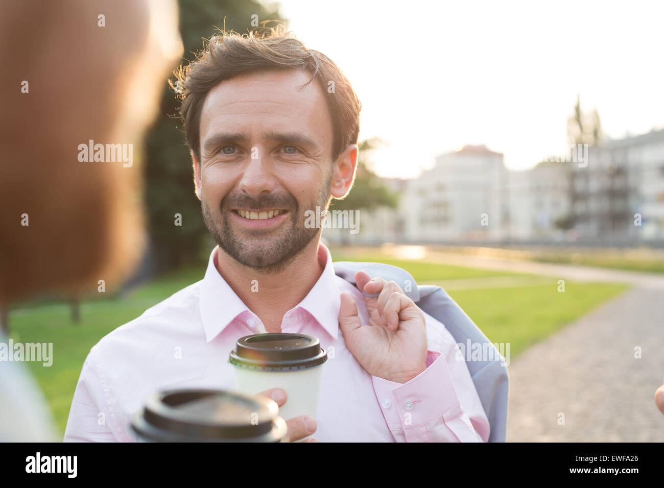 Empresario feliz con su colega en el parque en día soleado Foto de stock