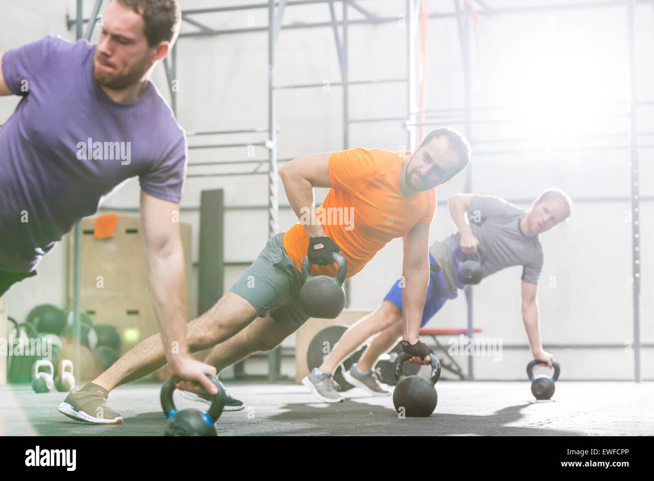 Los hombres ejerciendo con kettlebells en gimnasio crossfit Foto de stock