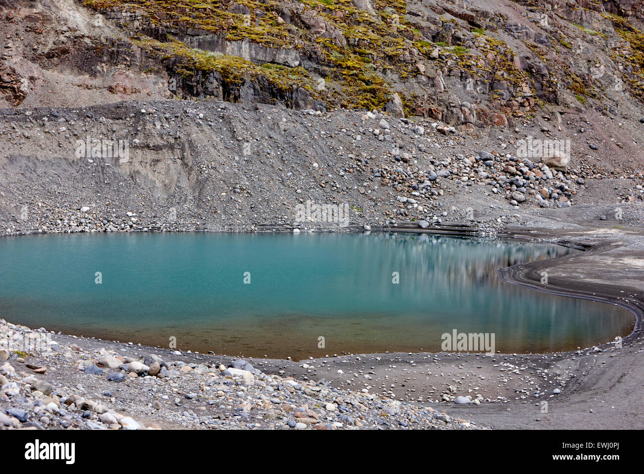 Hervidora agujero formaciones rocosas llenas con agua azul dejados por los glaciares de Islandia Foto de stock
