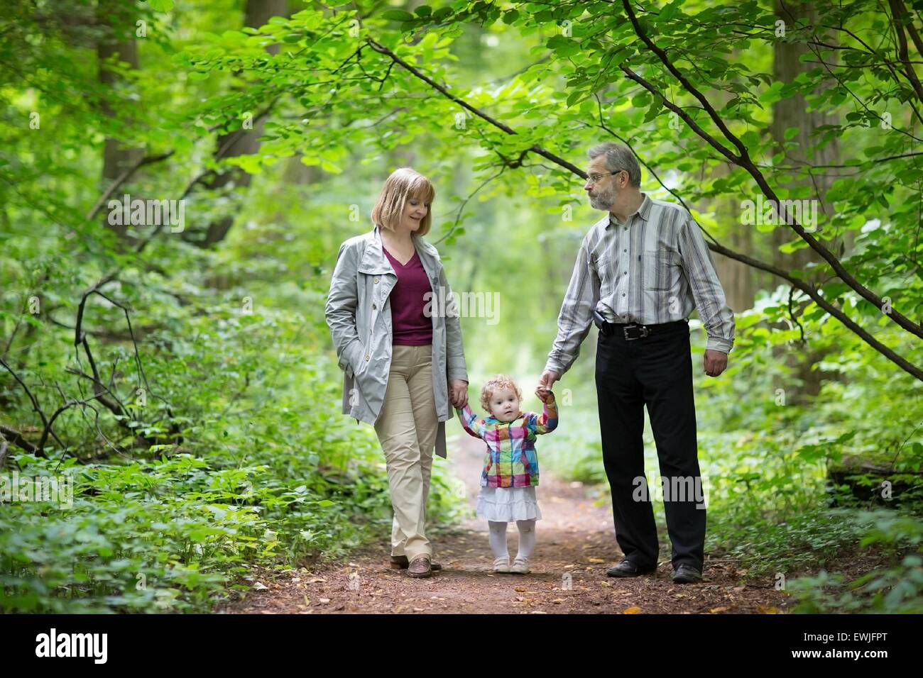 Los jóvenes abuelos bebé jugando con su nieta en un parque de otoño Foto de stock