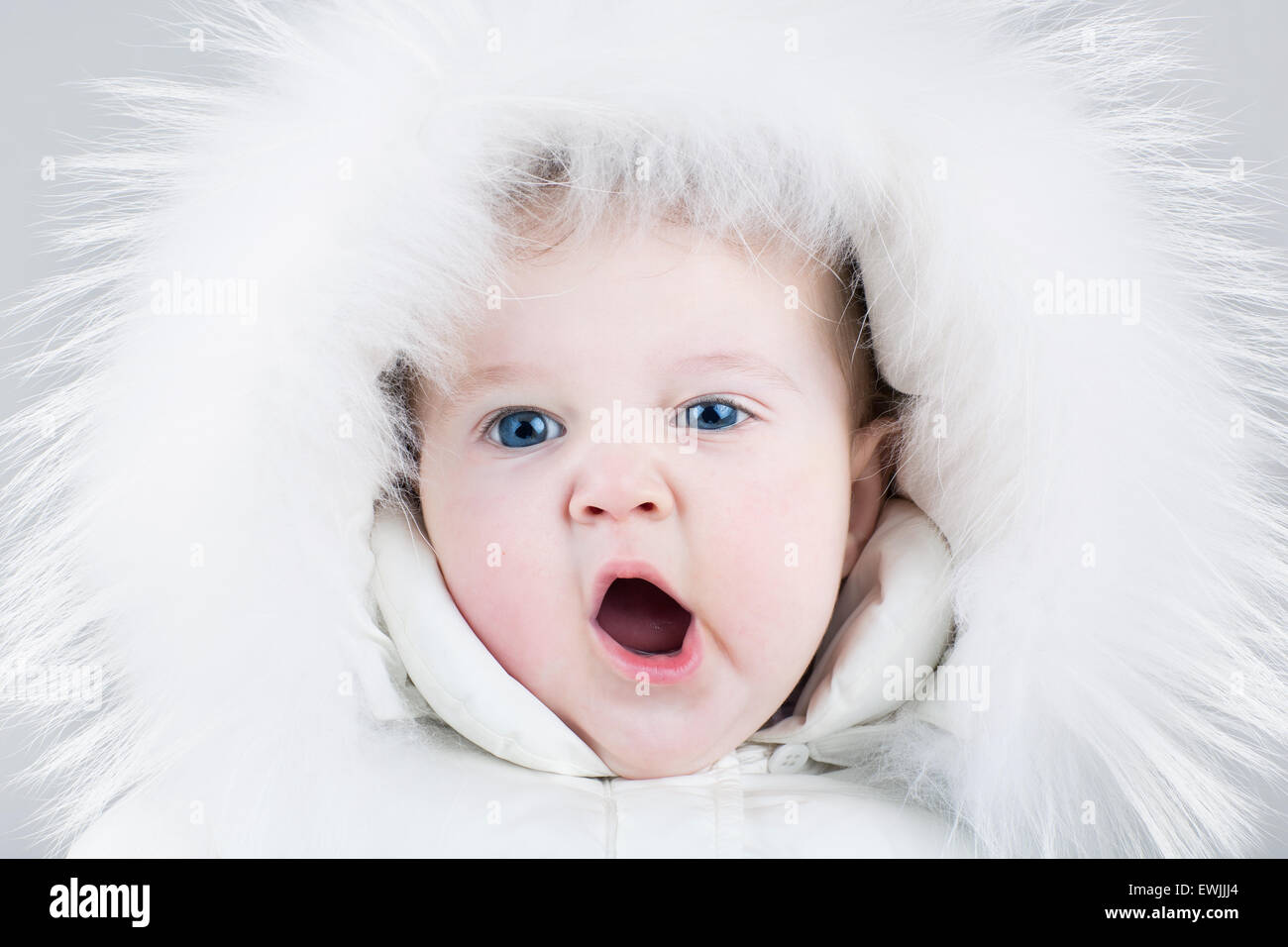 Bostezo lindo bebé niña llevaba un enorme sombrero de piel blanca y una  cálida chaqueta invierno listo para un paseo en un día frío Fotografía de  stock - Alamy