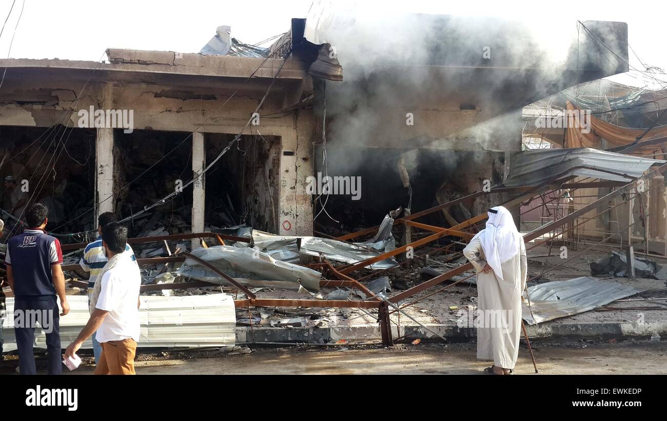 Fallujah, Irak. El 28 de junio de 2015. Las personas se reúnen alrededor de un edificio destruido tras un ataque aéreo de la Fuerza Aérea iraquí en el Estado Islámico (ES) militantes incautadas en la ciudad de Faluya, a unos 50 kilómetros al oeste de Bagdad, Iraq, el 28 de junio de 2015. Al menos 10 personas resultaron muertas y otras 19 heridas durante el atentado del domingo. © Sami Jawad/Xinhua/Alamy Live News Foto de stock