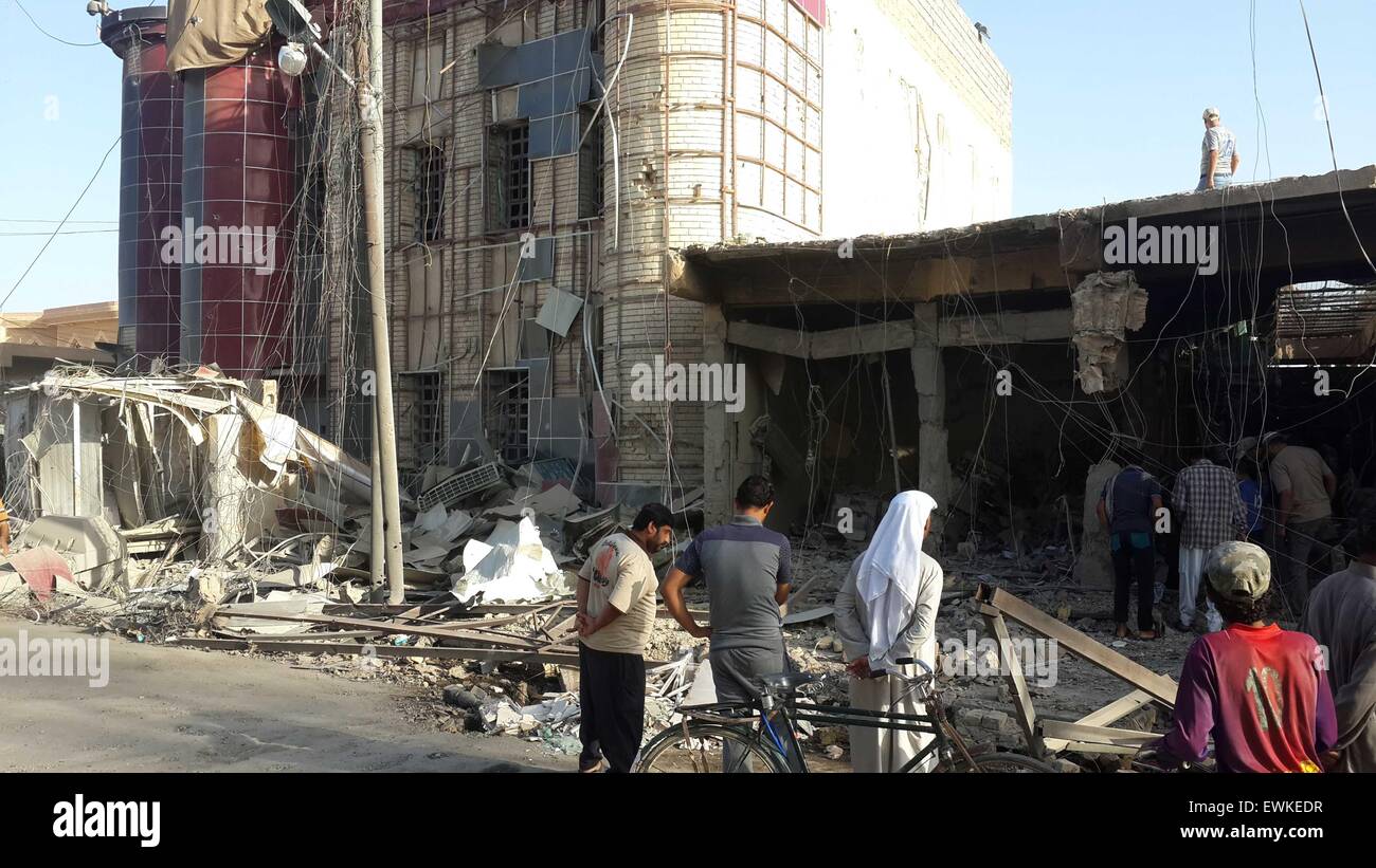 Fallujah, Irak. El 28 de junio de 2015. Las personas se reúnen alrededor de un edificio destruido tras un ataque aéreo de la Fuerza Aérea iraquí en el Estado Islámico (ES) militantes incautadas en la ciudad de Faluya, a unos 50 kilómetros al oeste de Bagdad, Iraq, el 28 de junio de 2015. Al menos 10 personas resultaron muertas y otras 19 heridas durante el atentado del domingo. © Sami Jawad/Xinhua/Alamy Live News Foto de stock