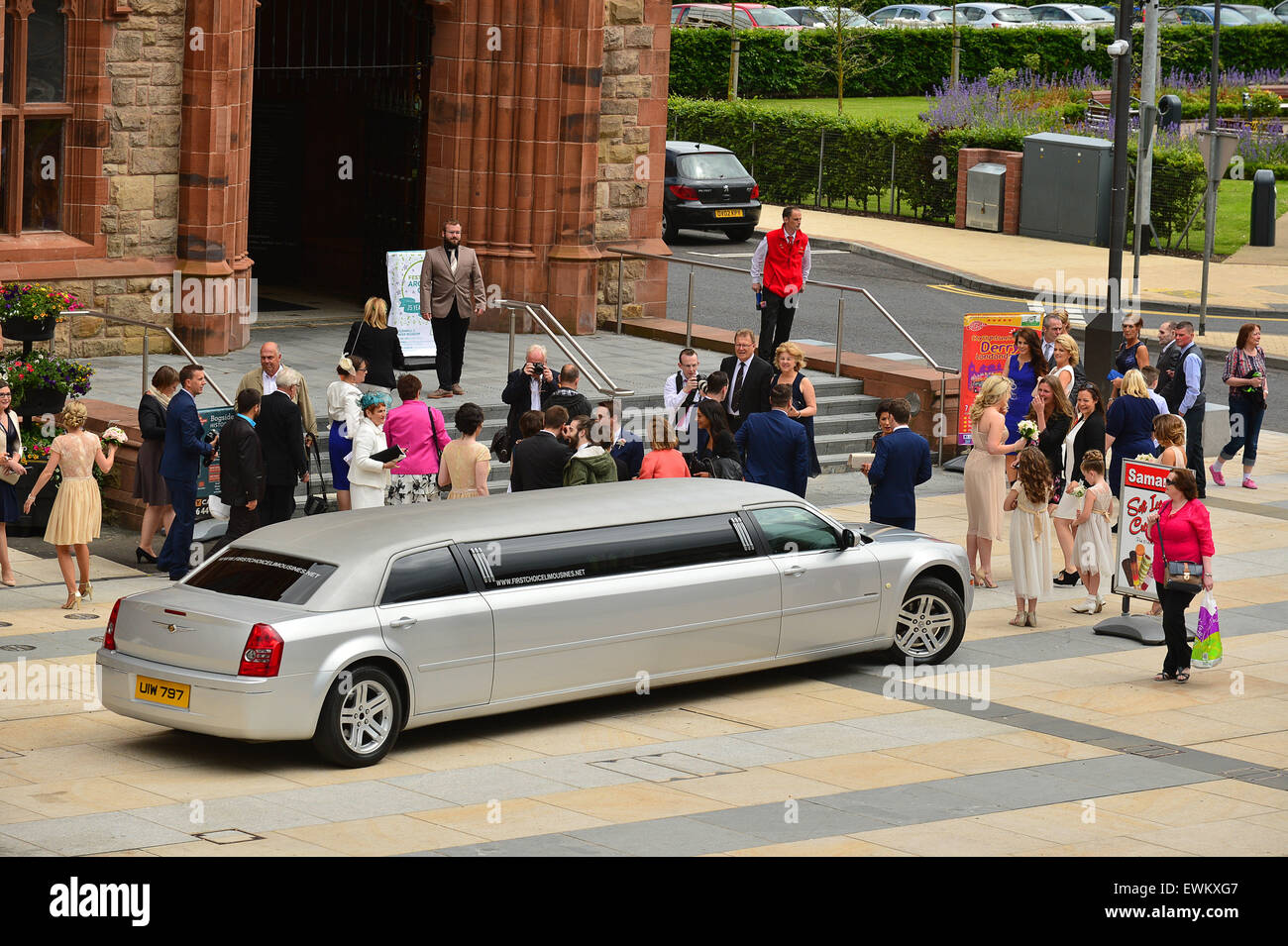La lechada de boda llega por 8 plazas Limusina Chrysler plateado en el Guildhall, Derry, en Londonderry, Irlanda del Norte Foto de stock
