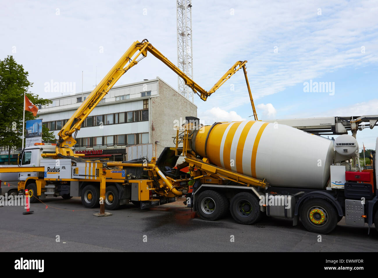 Edificio en construcción con camiones entregando el hormigón, Finlandia Foto de stock