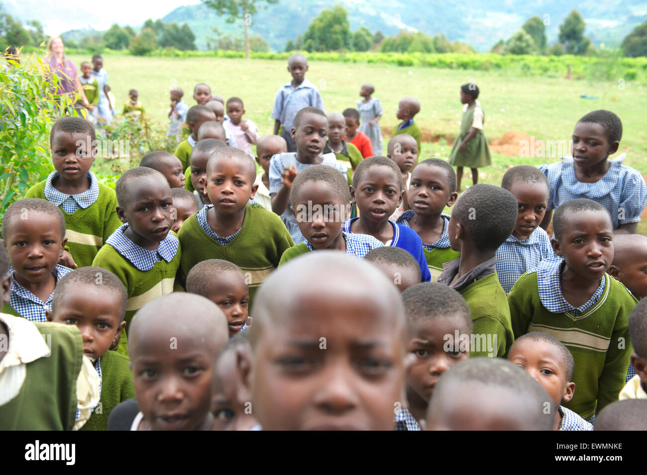 Grupo de escolares ugandeses de una escuela rural mirando a la cámara mientras fuera Foto de stock