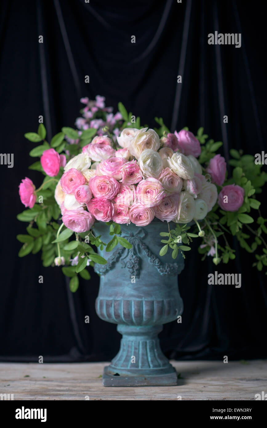 Bouquet de rosas blancas y ranúnculos en blue urn Foto de stock
