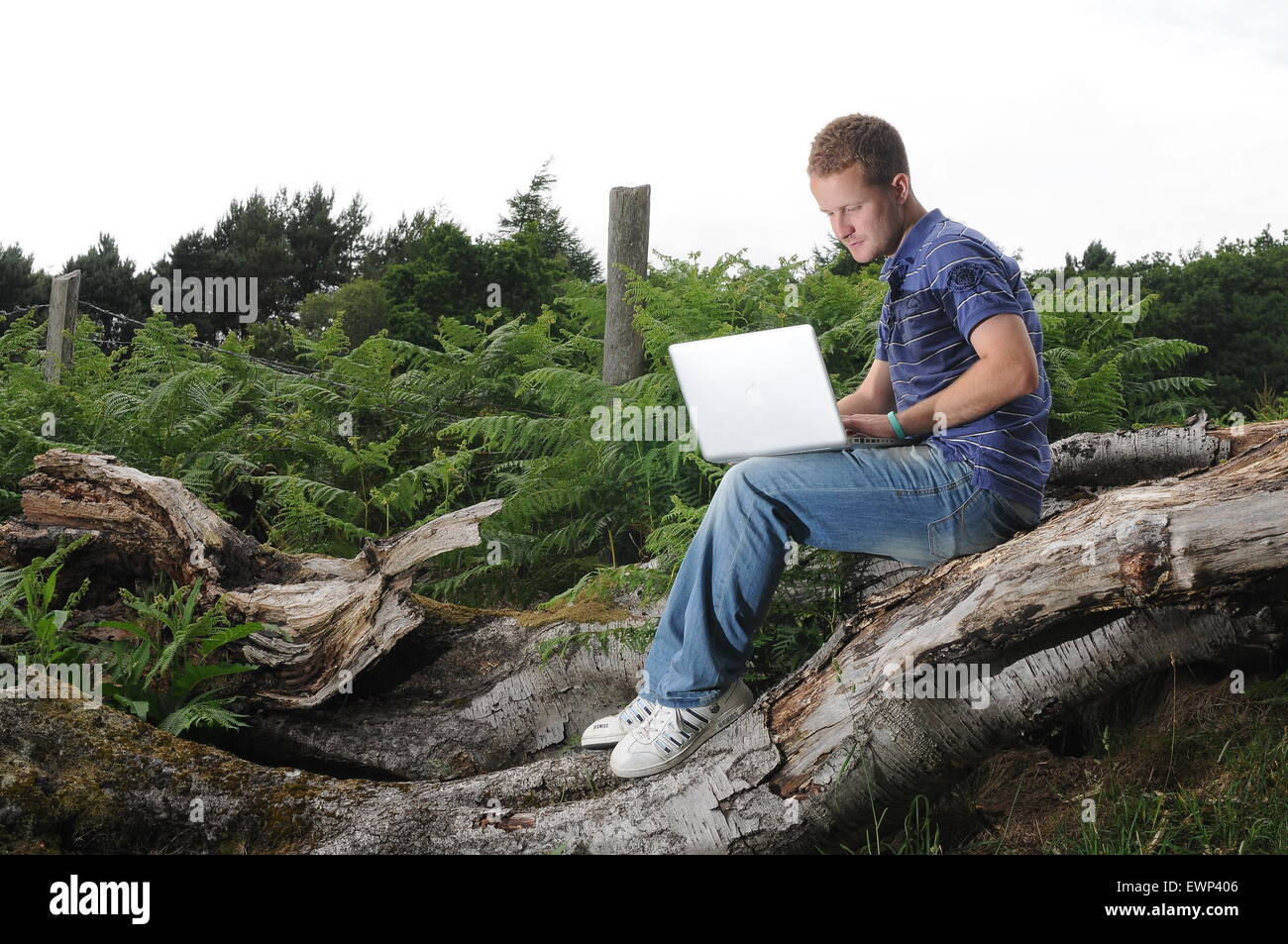 Un hombre usa una conexión a internet de banda ancha en el exterior en un entorno rural. Foto de stock