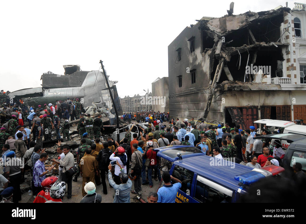 De Medan, Indonesia. 30 de junio de 2015. Las personas se reúnen en el sitio del accidente de un avión militar indonesio Hercules C-130 en la capital de la provincia de Sumatra Norte de Medan, Indonesia, 30 de junio de 2015. Unas 113 personas se encontraban a bordo del avión militar que se estrelló en el centro de la ciudad de Medan, el jefe de la Fuerza Aérea del país, dijo el martes. Crédito: Andi/Xinhua/Alamy Live News Foto de stock