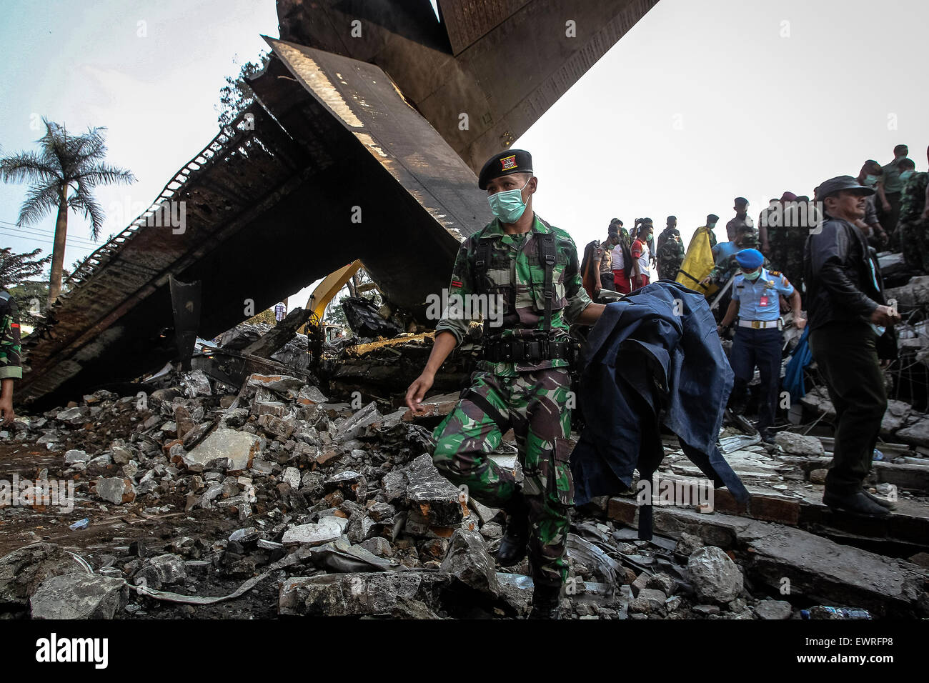 De Medan, Indonesia. 30 de junio de 2015. Los miembros de seguridad trabajan en el lugar del accidente de un avión militar indonesio Hercules C-130 en la capital de la provincia de Sumatra Norte de Medan, Indonesia, del 30 de junio de 2015. Unas 113 personas se temía que hubieran muerto después de un avión militar que se estrelló en el centro de indonesia de Sumatra del norte de la ciudad capital de Medan, el jefe de la Fuerza Aérea del país, dijo el martes. Crédito: Haryono/Xinhua/Alamy Live News Foto de stock