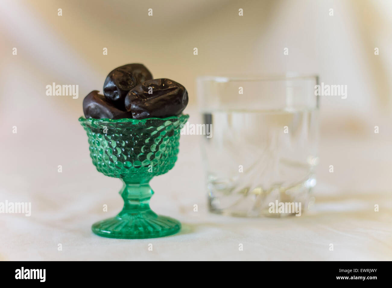 Iftar vaso de agua negra y fechas Foto de stock