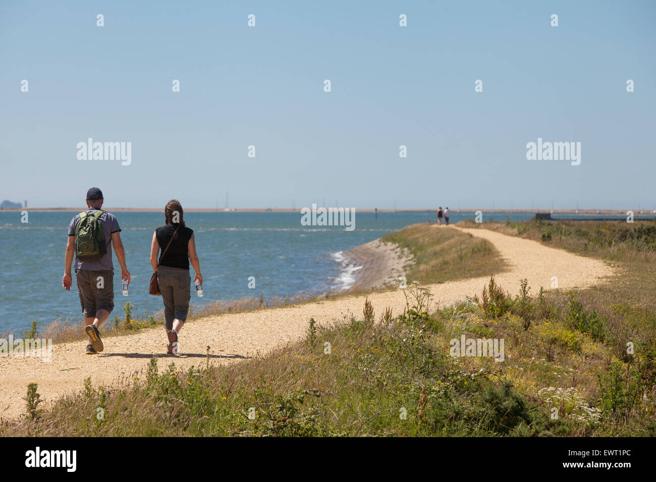 Los excursionistas en el Solent camino entre Lymington y Keyhaven Foto de stock