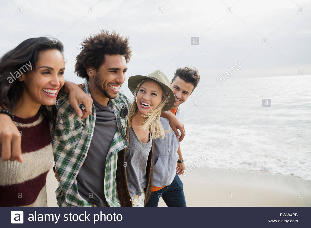 Amigos sonriente caminando en una fila en la playa Foto de stock