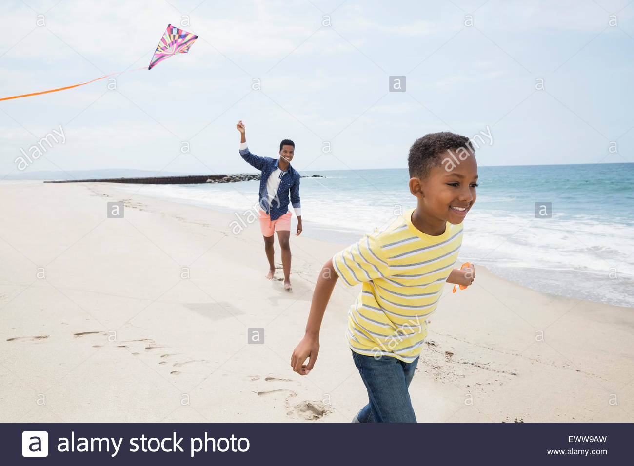 Padre e hijo volar cometas en la playa Foto de stock