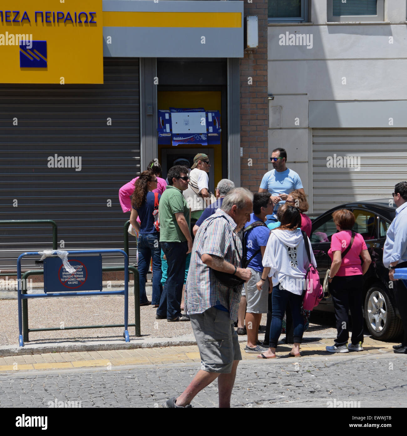 Cola de gente esperando por el dinero de un cajero automático en frente de un banco cerrado después de los controles de capital fueron implementadas. Atenas, Grecia. Foto de stock