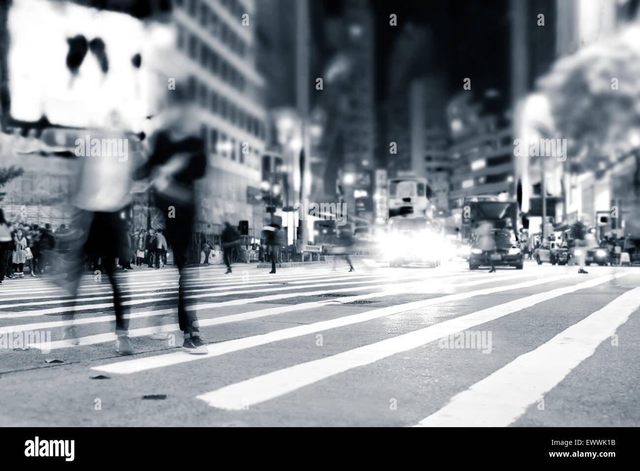 Imagen borrosa de gente moviéndose en las concurridas calles de la ciudad de noche. Tonificación de arte abstracto de fondo urbano. Hong Kong Foto de stock