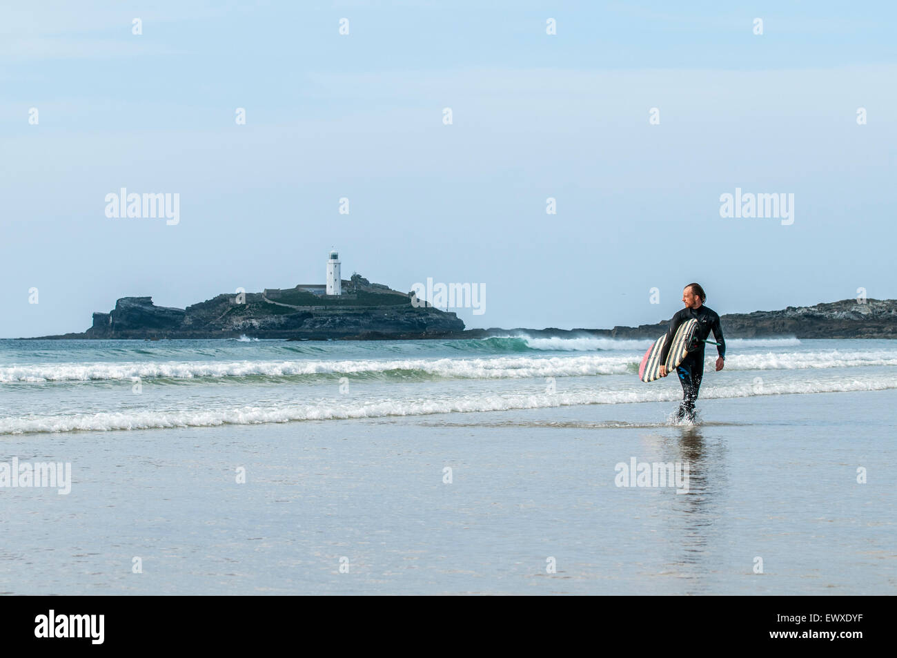 Surfer mirando hacia el mar después de un surf en godrevy, Cornwall. Foto de stock