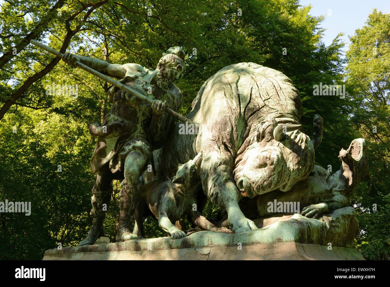 Parque Tiergarten, Berlín. Estatua de un bisonte siendo asesinado por un cazador con una lanza. Foto de stock