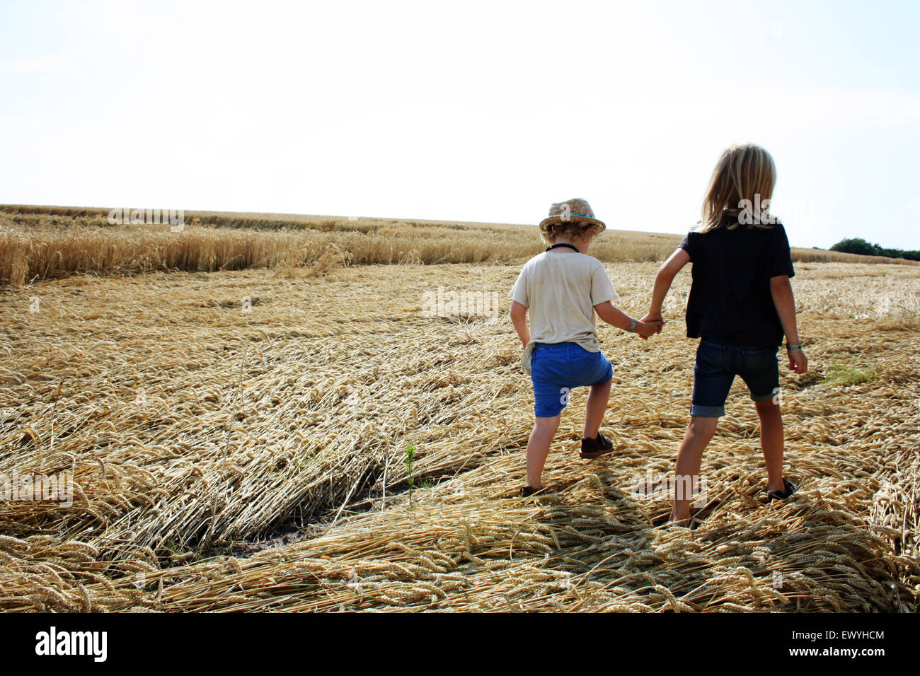 Vista trasera de dos niños tomados de las manos dando un paseo Foto de stock