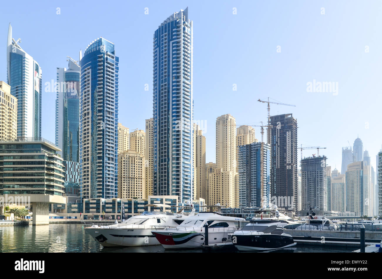Yates enfrente de la moderna y futurista de edificios altos, las torres y los hoteles del puerto deportivo de Dubai, Emiratos Árabes Unidos Foto de stock