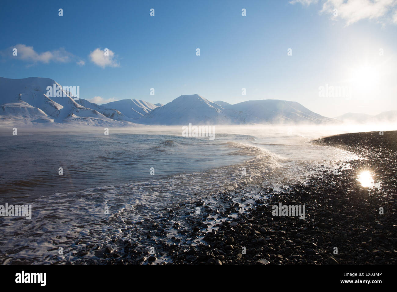 Vista de la soleada costa y montañas distantes, Svalbard, Noruega Foto de stock