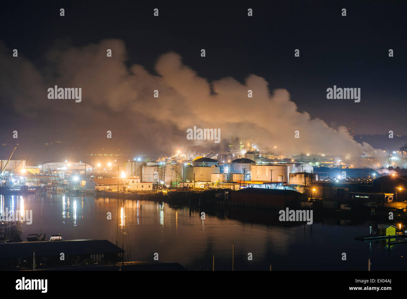 Tanques de almacenamiento de petróleo y chimeneas en Puget Sound waterfront en la noche, Tacoma, Estado de Washington, EE.UU. Foto de stock